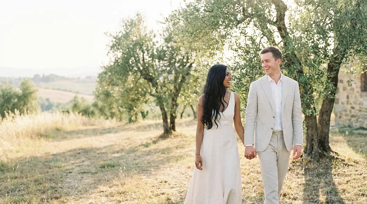 Aanya and Daniel walking through an olive grove in Tuscany